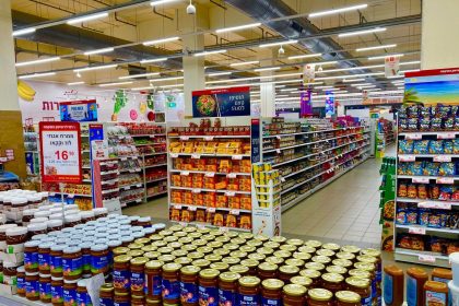 Corredor de supermercado com prateleiras abastecidas e diversos produtos organizados
