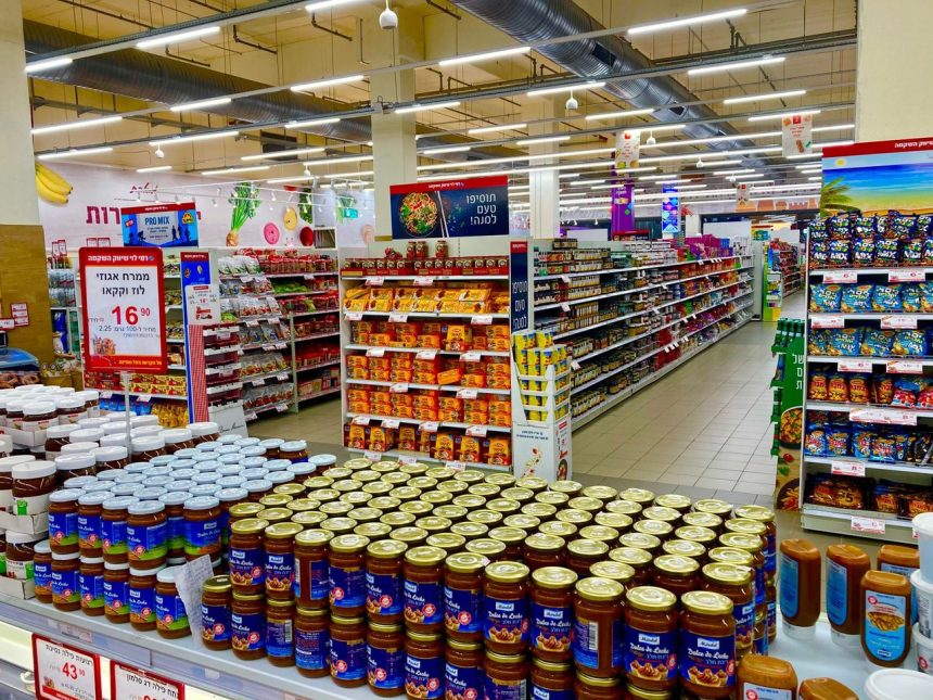 Corredor de supermercado com prateleiras abastecidas e diversos produtos organizados