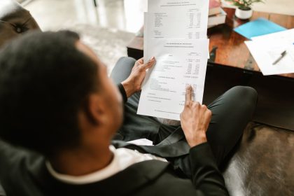 Profissional analisa documentos financeiros e planilhas em uma mesa de escritório.